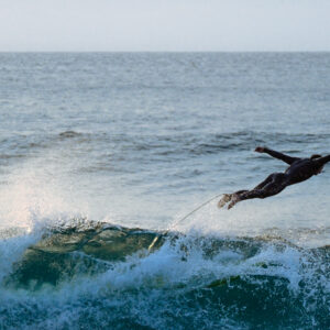 Surfer flying off a wave captured perfectly in a swan position